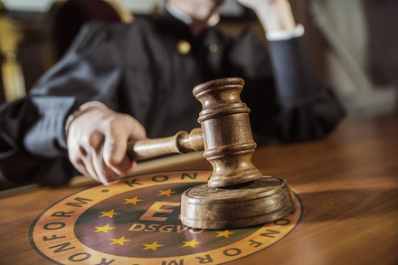 Ein Richterhammer schlägt auf ein DSVGO-Schild