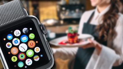 Eine Uhr und ein Kellner im Hintergrund