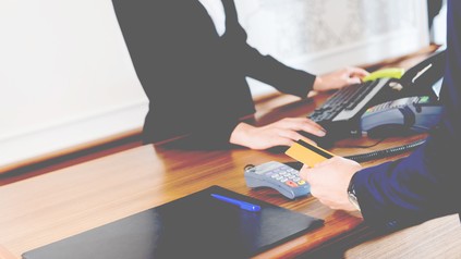 Mann bezahlt mit Karte am Schalter