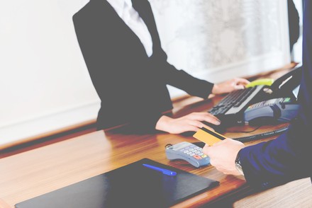 Mann bezahlt mit Karte am Schalter