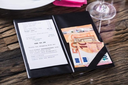 Eine Rechnung eines Restaurants und das hierfür bezahlte Geld