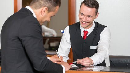 Ein Gast unterschrieb einen Hotel-Meldeschein an der Rezeption