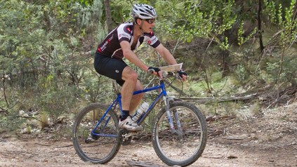 Ein Mountainbiker bei der Fahrt durch einen Wald