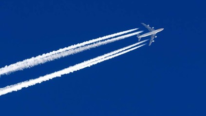 Ein Flugzeug im Himmel erzeugt Kondensstreifen