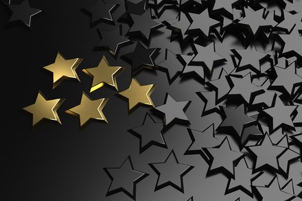 Ein goldener Stern unter vielen schwarzen Sternen