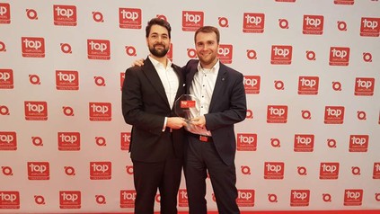 Zwei Männer halten die Auszeichnung für Steigenberger hoch