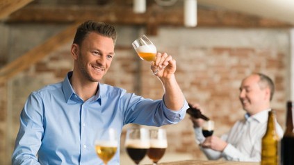 Mann schwenkt Bier im Glas