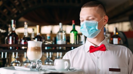 Ein Kellner mit Gesichtsmaske