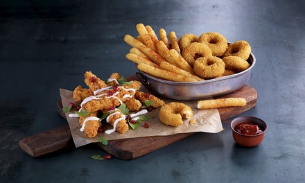 Homestyle Chik’n® Fingers Buttermilk, vegetarische Mozzarella Fries und Mozzarella Onion Rings angerichtet in einer Metallschale auf einem Holzbrett