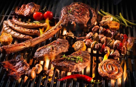 Ein Grill mit diversen Fleischspeisen darauf