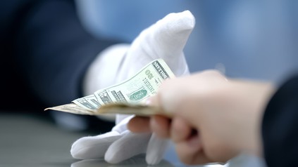 Jemand gibt Gled an einen Portier