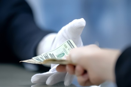 Jemand gibt Gled an einen Portier