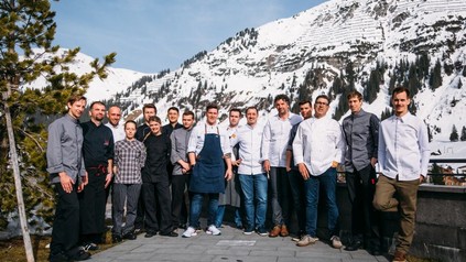 Die Spitzenköche bei einem Gruppenfoto vor verschneiten Bergen