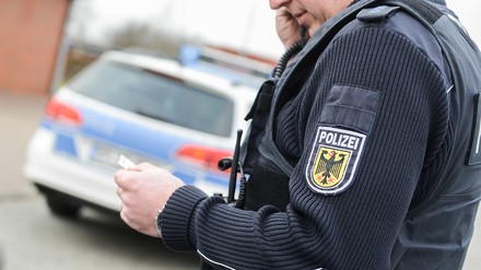Polizist telefoniert und liest eine Notiz ab