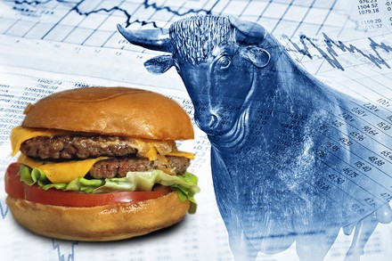 Ein Burger neben einer Tafel mit Aktienkursen