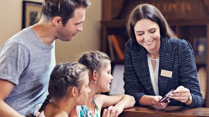 Glückliche Familie checkt im Hotel ein
