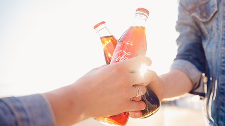 Freunde stoßen mit Cola an