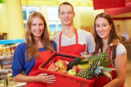 Mitarbeiter eines Supermarkts mit einem Korb Lebensmittel