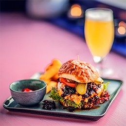 Nahaufnahme des taste!-Burgers auf einem türkisen Teller