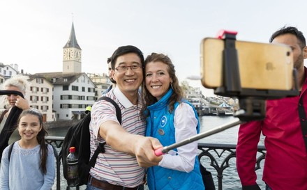 Paar fotografiert sich mit Selfie-Stick auf Brücke
