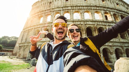 Fröhliches Paar fotografiert sich selbst vor dem Kolloseum