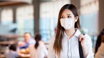 Eine Frau mit Gesichtsmaske im Restaurant