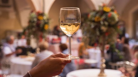 Eine Hand hält ein Glas Wein