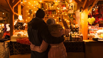 Derzeit gilt in Bayern noch das Rahmenkonzept, wonach Weihnachtsmärkte im Freien stattfinden dürfen – ohne Alkoholverbot. (Foto: © Syda Productions/stock.adobe.com)
Paar an einem Stand auf dem Weihnachtsmarkt