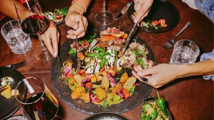 Gäste im Restaurants bedienen sich an der geteilten Platte in der Mitte des Tisches