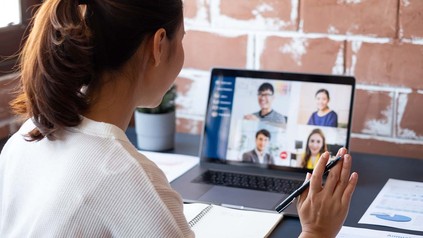 Frau arbeitet im Home-Office und skyped dabei mit den Kollegen