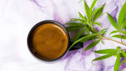 Eine Tasse Kaffee und eine Cannabispflanze