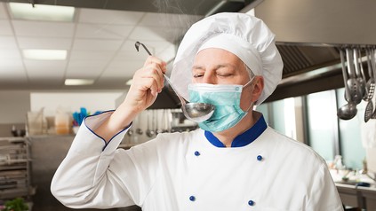 Ein Koch mit Mundschutzmaske