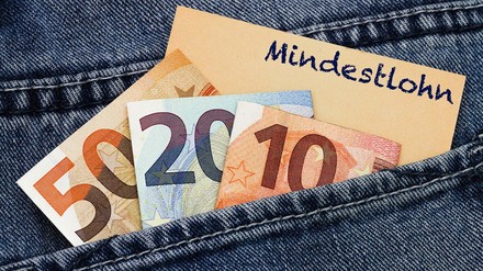 Hosentasche mir Geldscheinen und einem Zettel mit der Aufschrift Mindestlohn