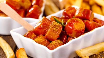 Currywurst in einer Pappschale.