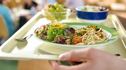 Essenstablett wird getragen.