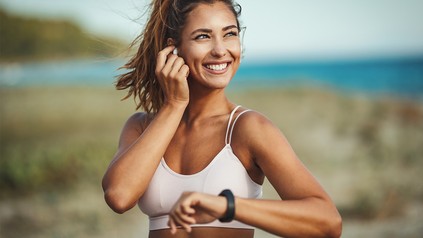 Frau lächelt in Sportkleidung lächelt in die Sonne.