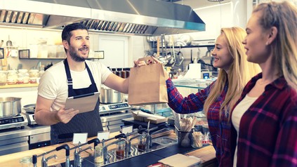 Zwei Frauen nehmen Essen mit.