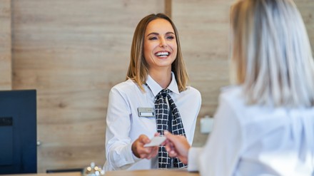 Receptionist and businesswoman at hotel front desk