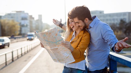 Glückliche Touristen mit einer Karte in mitten in der Stadt