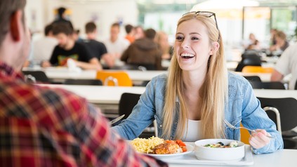 Frau isst in der Mensa