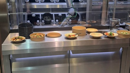 Robo-Koch schwingt den Kochlöffel.