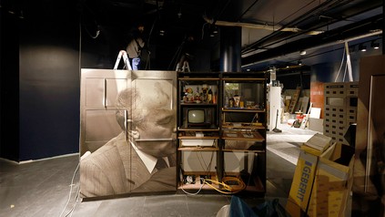 Bauarbeiter arbeiten hinter Ausstellungsstücken auf der Baustelle bei Renovierungsarbeiten im DDR-Museum.