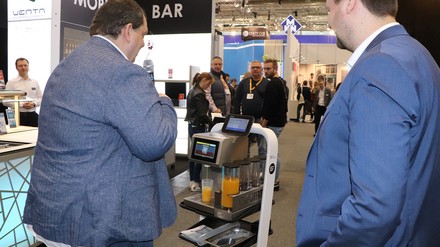 Ein Roboter mit integrierter Cocktailmaschine brachte den Teilnehmern des Trendrundgangs jeweils ein Glas Orangensaft. (Foto: © HOGAPAGE/Sarah Kleinen)