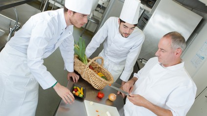 Drei Köche diskutieren bei der Arbeit