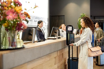 Frau vor einem Desinfektionsmittelspender