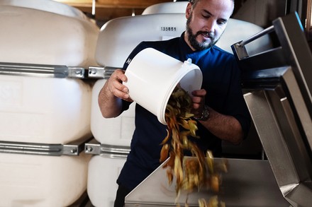 Thomas Messerer schüttet Essensreste in eine Resteverwertungsanlage von MEIKO