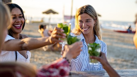 Frauen genießen einen Cocktail an einer Strandar.