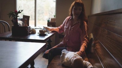 Eine Frau in einem Café versucht ein Baby zu beruhigen