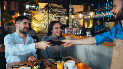 Paar im Restaurant beim Bezahlen