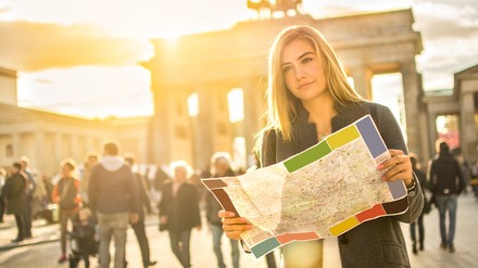 Frau mit Stadtkarte vor dem Brandenburger Tor